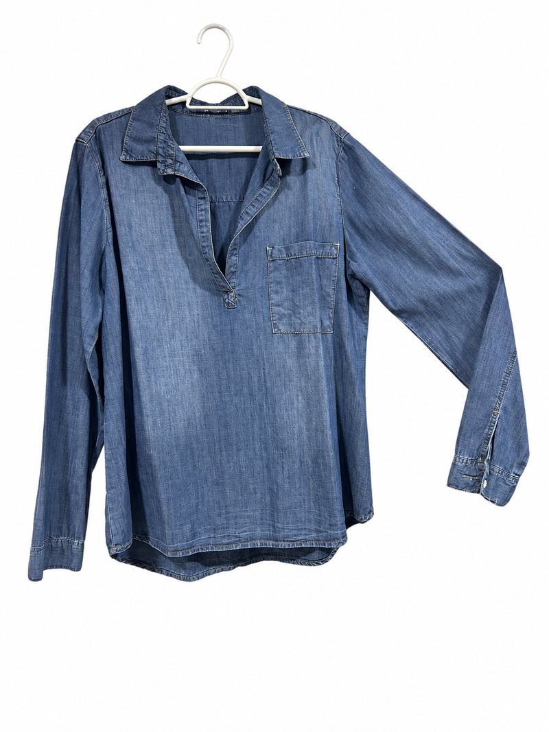 Camisa jeans azul de manga longa, com gola e bolso frontal