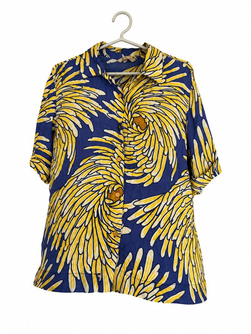 Frente da camisa Totten azul, com estampa de folhas amarelas